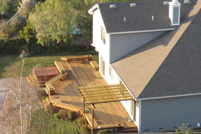 Large stained timber deck with steps at the back of a two storey house