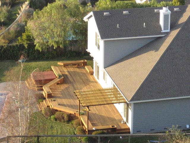 Large stained timber deck with steps at the back of a two storey house