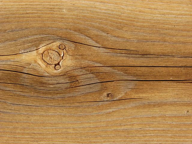 Close up of weathered timber deck board grain with a knot