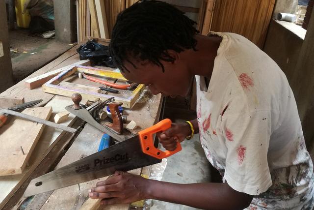 Carpenter cutting timber at a workbench